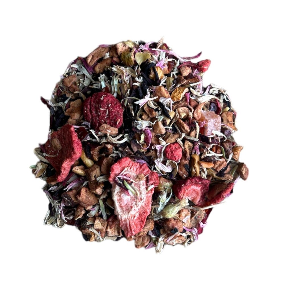 Be Mine Chocolate Strawberry Tea Blend with dark chocolate, strawberry, apple, hibiscus, rosehip, papaya, cocoa, and cornflower petals in a tea cup.