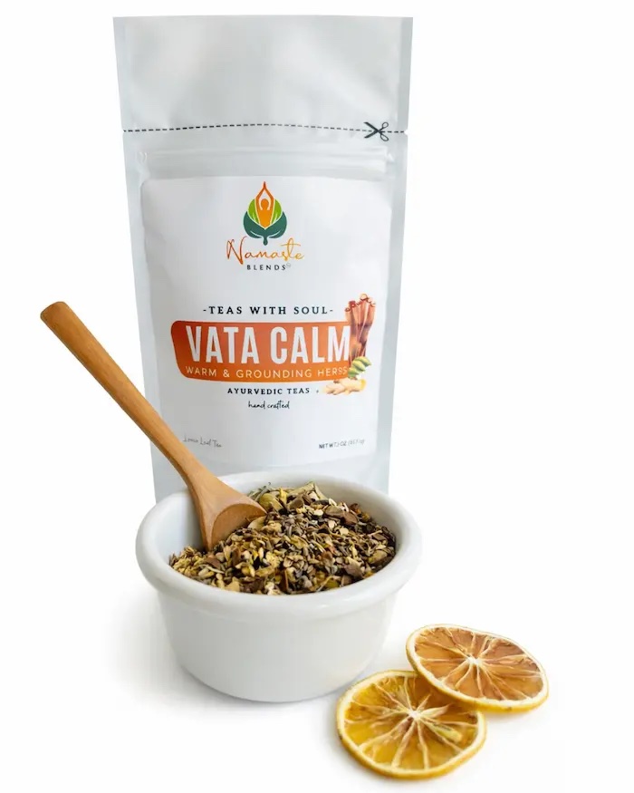 Loose leaf herbal tea for Vata balance displayed in a minimalist setting with a white mug and soft neutral tones, caffeine free herbal tea with visible dried botanicals designed for calming daily rituals and grounding routines, warming loose leaf tea blend for relaxation and mindful living, cozy tea aesthetic, herbal tea for evening wind down and gentle routine support, wellness tea gift idea, loose leaf tea pouch presentation for balanced self care lifestyle