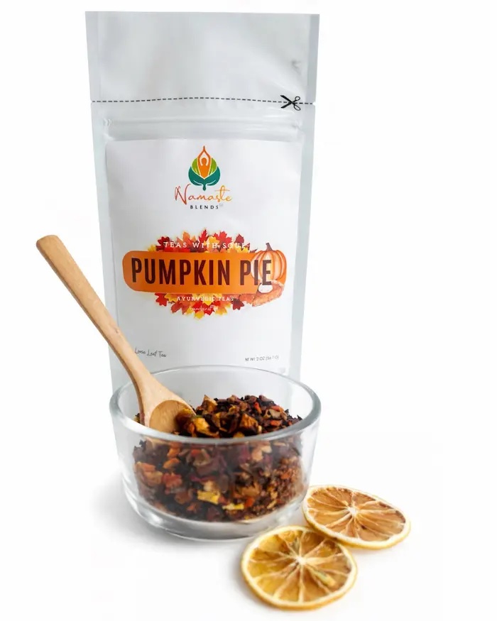 Loose leaf pumpkin pie herbal tea blend displayed in a minimalist setting with a white mug and warm neutral tones, caffeine free herbal tea with visible spices inspired by pumpkin pie flavors, cozy loose leaf tea for fall rituals and mindful living, comforting tea aesthetic, spiced herbal tea blend for warming daily routine, wellness tea gift idea, loose leaf tea pouch presentation for self care and seasonal lifestyle