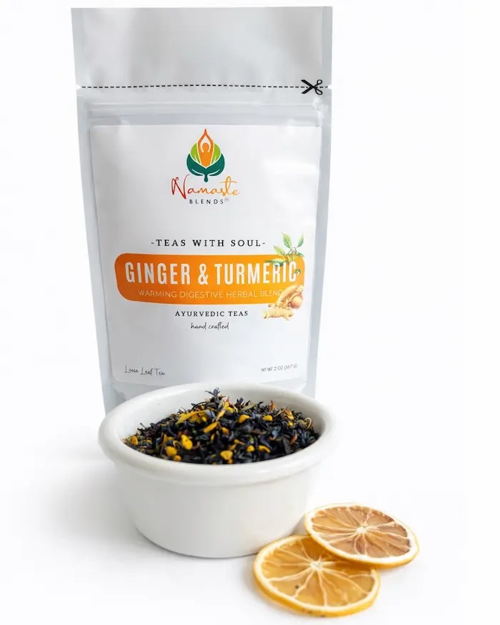 Loose leaf ginger turmeric herbal tea blend displayed in a minimalist setting with a white mug and neutral background, caffeine free herbal tea with visible dried ginger pieces and golden turmeric root, warming loose leaf tea for daily wellness rituals and mindful living, cozy tea aesthetic, natural herbal tea blend for grounding routine, digestive support lifestyle, wellness tea gift idea, loose leaf tea pouch presentation for self care and balanced habits