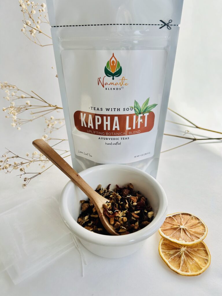 kapha lift herbal tea bags displayed in a minimalist setting with a white mug and warm neutral tones, caffeine free herbal tea sachets with visible spices like ginger clove and citrus pieces, energizing botanical blend designed for daily wellness rituals and mindful living, cozy tea aesthetic, herbal tea for energy and balance routine, wellness tea gift idea, tea bags presentation for self care and uplifting lifestyle