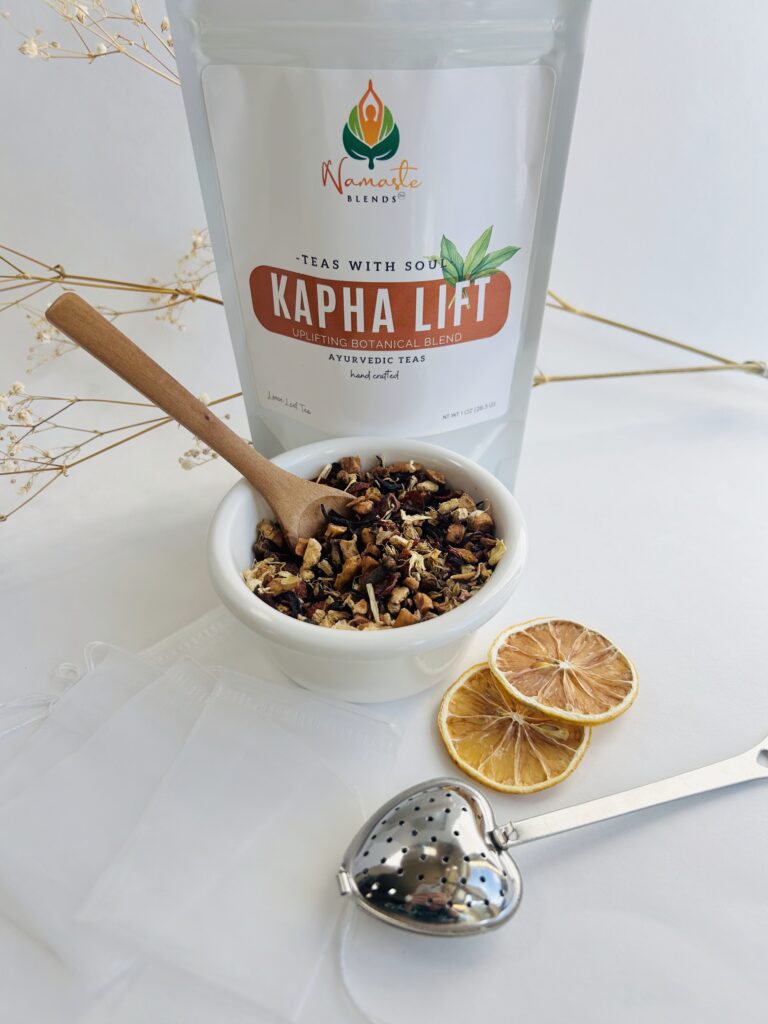 kapha lift herbal tea bags displayed in a minimalist setting with a white mug and warm neutral tones, caffeine free herbal tea sachets with visible spices like ginger clove and citrus pieces, energizing botanical blend designed for daily wellness rituals and mindful living, cozy tea aesthetic, herbal tea for energy and balance routine, wellness tea gift idea, tea bags presentation for self care and uplifting lifestyle