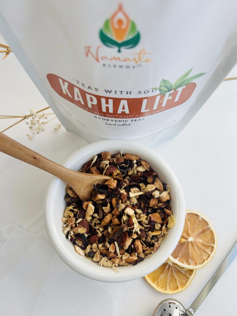 kapha lift herbal tea bags displayed in a minimalist setting with a white mug and warm neutral tones, caffeine free herbal tea sachets with visible spices like ginger clove and citrus pieces, energizing botanical blend designed for daily wellness rituals and mindful living, cozy tea aesthetic, herbal tea for energy and balance routine, wellness tea gift idea, tea bags presentation for self care and uplifting lifestyle