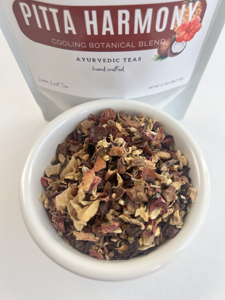 pitta harmony herbal tea bags displayed in a minimalist setting with a white mug and soft neutral tones, caffeine free herbal tea sachets with visible floral botanicals like hibiscus and rose, cooling herbal blend designed for daily wellness rituals and mindful living, cozy tea aesthetic, herbal tea for calm and balance, wellness tea gift idea, tea bags presentation for self care and refreshing routine