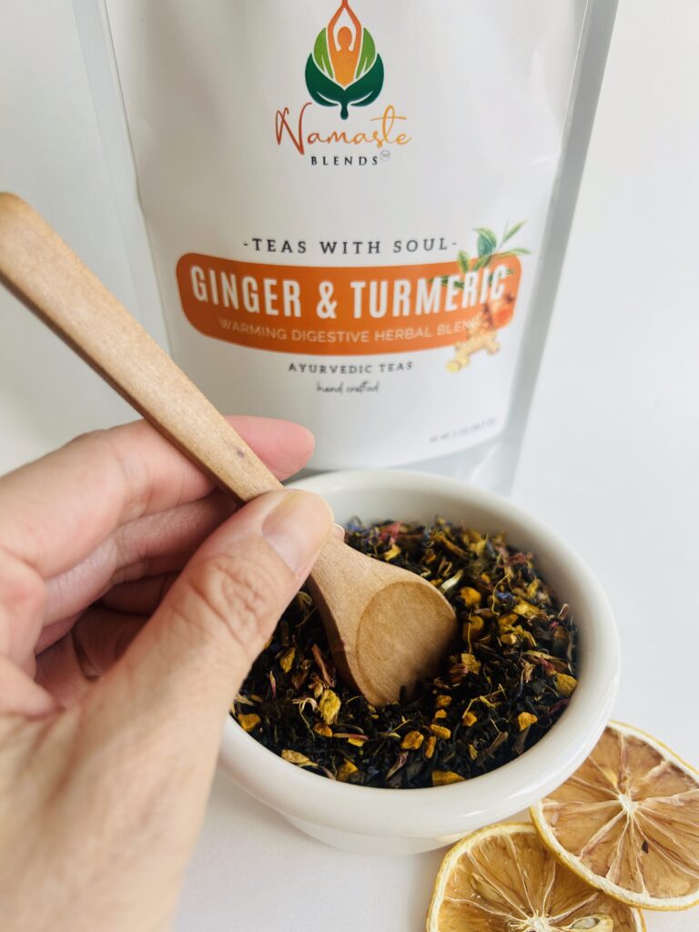ginger turmeric herbal tea displayed in a minimalist setting with a white mug and warm neutral tones, caffeine free herbal tea with visible ginger pieces and turmeric root, warming botanical blend designed for daily wellness rituals and mindful living, cozy tea aesthetic, herbal tea for comfort and balance routine, wellness tea gift idea, tea presentation for self care and grounding daily habits