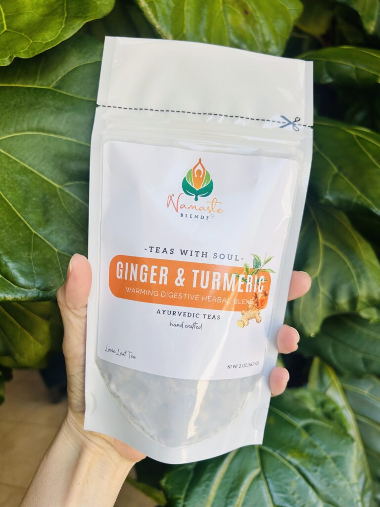 ginger turmeric herbal tea displayed in a minimalist setting with a white mug and warm neutral tones, caffeine free herbal tea with visible ginger pieces and turmeric root, warming botanical blend designed for daily wellness rituals and mindful living, cozy tea aesthetic, herbal tea for comfort and balance routine, wellness tea gift idea, tea presentation for self care and grounding daily habits