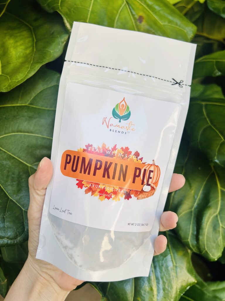 pumpkin pie herbal tea displayed in a minimalist setting with a white mug and warm neutral tones, caffeine free herbal tea with visible spices and pumpkin pieces, cozy spiced tea blend designed for daily wellness rituals and mindful living, fall tea aesthetic, herbal tea for comfort and warmth, wellness tea gift idea, tea presentation for self care and cozy lifestyle