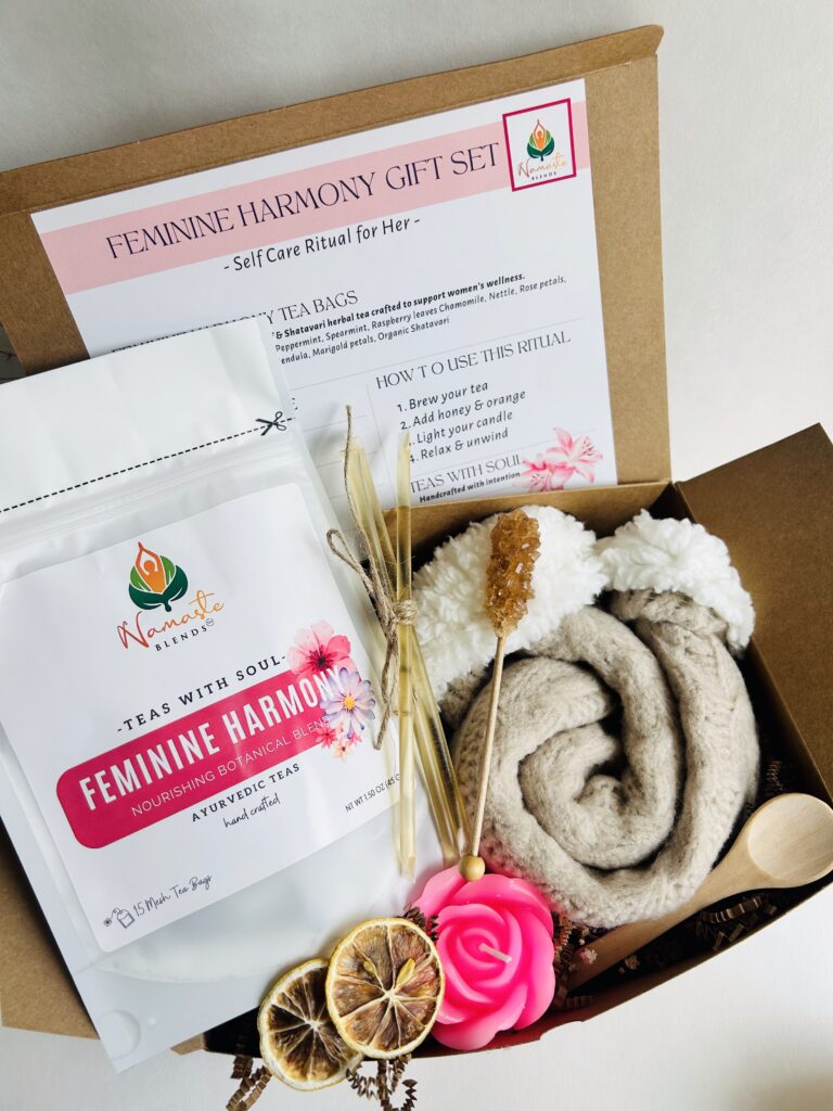 feminine support gift box displayed in a minimalist setting with a white mug and soft neutral tones, curated self care set featuring herbal tea bags, candle, cozy socks and sugar sticks, calming wellness box for women, relaxation gift aesthetic, cozy self care ritual set for comfort and balance, wellness gift presentation for nurturing routine and mindful living