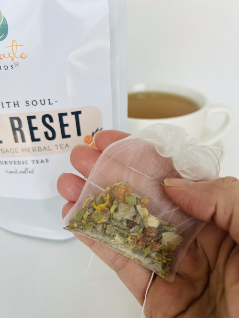 sage reset herbal tea bags displayed in a minimalist setting with a white mug and soft neutral tones, caffeine free herbal tea sachets with visible citrus pieces and sage leaves, refreshing botanical blend designed for daily wellness rituals and mindful living, cozy tea aesthetic, herbal tea for clarity and balance, wellness tea gift idea, tea bags presentation for self care and refreshing routine