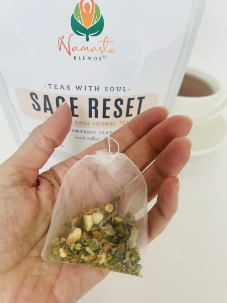 sage reset herbal tea bags displayed in a minimalist setting with a white mug and soft neutral tones, caffeine free herbal tea sachets with visible citrus pieces and sage leaves, refreshing botanical blend designed for daily wellness rituals and mindful living, cozy tea aesthetic, herbal tea for clarity and balance, wellness tea gift idea, tea bags presentation for self care and refreshing routine