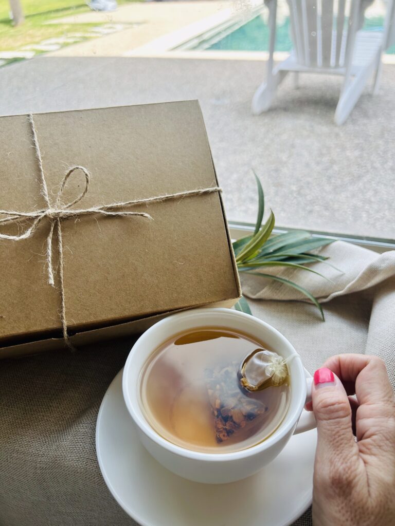 self care gift box displayed in a minimalist setting with a white mug and soft neutral tones, curated wellness set featuring herbal tea bags, lavender eye pillow, pillow mist, magnesium bath flakes and wooden spoon, calming spa gift aesthetic, relaxation gift box for stress relief and mindful living, cozy self care ritual set, wellness gift presentation for comfort and peaceful lifestyle