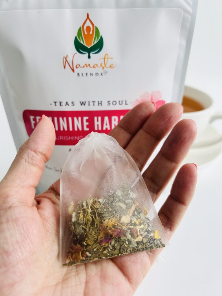 herbal tea bags for feminine balance displayed in a minimalist setting with a white mug and soft neutral tones, caffeine free herbal tea sachets with visible botanicals designed for women’s wellness rituals and mindful living, floral herbal tea for daily self care routine, cozy tea aesthetic, herbal tea for balance and comfort lifestyle, wellness tea gift for women, tea bags presentation for calm and nurturing routine