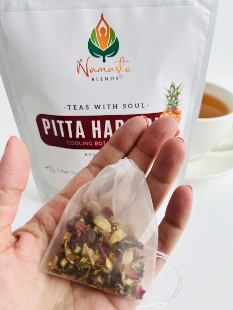 pitta harmony herbal tea bags displayed in a minimalist setting with a white mug and soft neutral tones, caffeine free herbal tea sachets with visible floral botanicals like hibiscus and rose, cooling herbal blend designed for daily wellness rituals and mindful living, cozy tea aesthetic, herbal tea for calm and balance, wellness tea gift idea, tea bags presentation for self care and refreshing routine