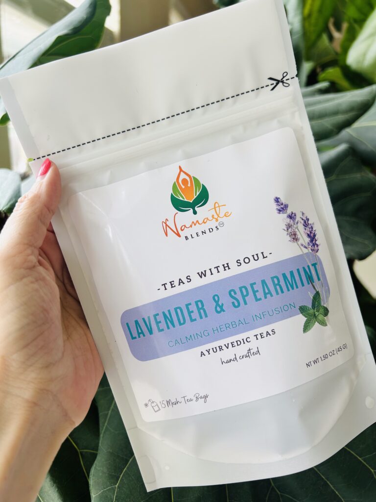 lavender spearmint herbal tea displayed in a minimalist setting with a white mug and soft neutral tones, organic caffeine free herbal tea with visible lavender buds and spearmint leaves, calming floral mint blend designed for daily wellness rituals and mindful living, cozy tea aesthetic, herbal tea for relaxation and balance, wellness tea gift idea, tea presentation for self care and peaceful lifestyle