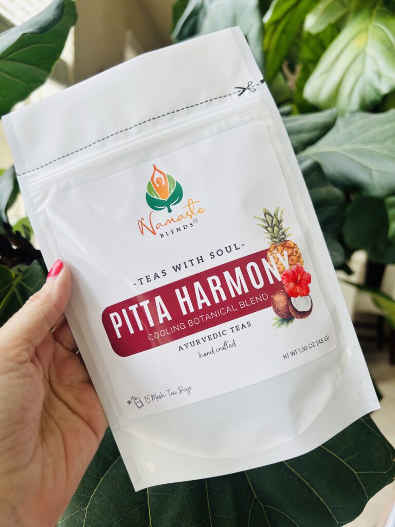 pitta harmony herbal tea bags displayed in a minimalist setting with a white mug and soft neutral tones, caffeine free herbal tea sachets with visible floral botanicals like hibiscus and rose, cooling herbal blend designed for daily wellness rituals and mindful living, cozy tea aesthetic, herbal tea for calm and balance, wellness tea gift idea, tea bags presentation for self care and refreshing routine