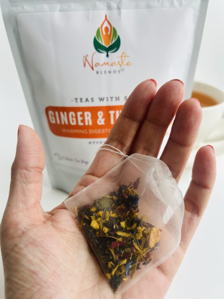 ginger turmeric herbal tea displayed in a minimalist setting with a white mug and warm neutral tones, caffeine free herbal tea with visible ginger pieces and turmeric root, warming botanical blend designed for daily wellness rituals and mindful living, cozy tea aesthetic, herbal tea for comfort and balance routine, wellness tea gift idea, tea presentation for self care and grounding daily habits