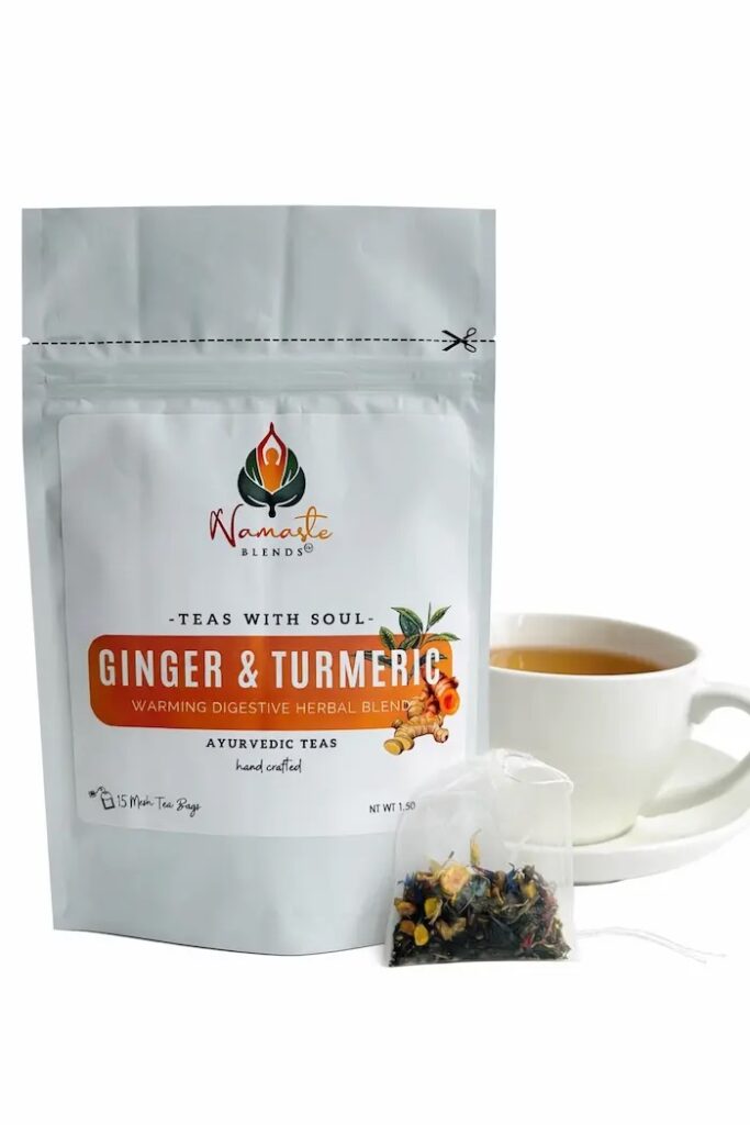 ginger turmeric herbal tea displayed in a minimalist setting with a white mug and warm neutral tones, caffeine free herbal tea with visible ginger pieces and turmeric root, warming botanical blend designed for daily wellness rituals and mindful living, cozy tea aesthetic, herbal tea for comfort and balance routine, wellness tea gift idea, tea presentation for self care and grounding daily habits