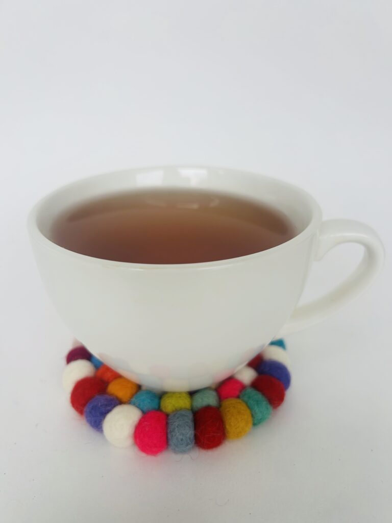 floral felt ball coasters soft pom pom coasters set of 4 colorful flower coaster set tea cup coaster cozy tea setup table decor tea accessory soft coaster set for mugs handmade style coaster aesthetic tea ritual decor home decor tea lovers gift soft felt coaster set