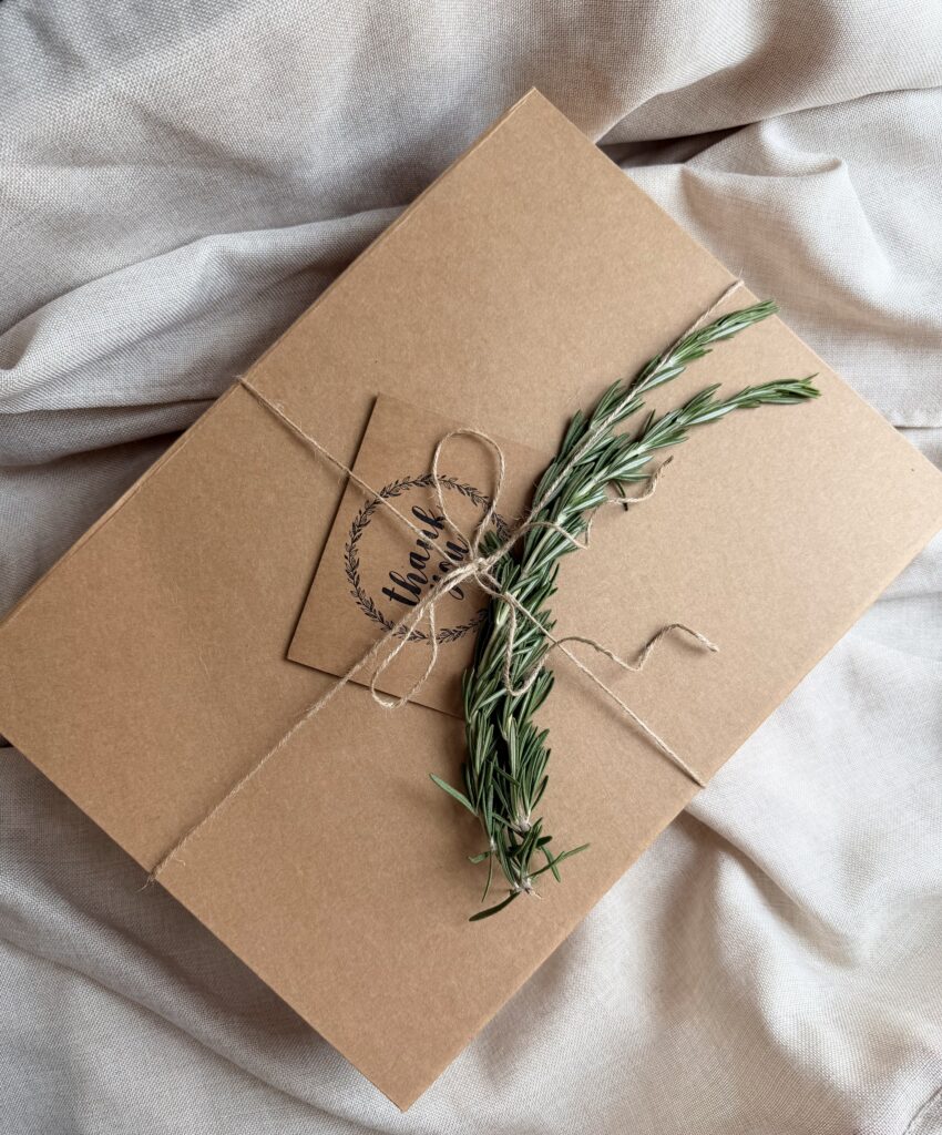 Botanical Reset Gift Box featuring Daily Ritual Herbal Tea, cozy blanket, eye mask, magnesium bath flakes, pillow mist, honey stick, ceramic tea cup, and wellness accessories by Namaste Blends.