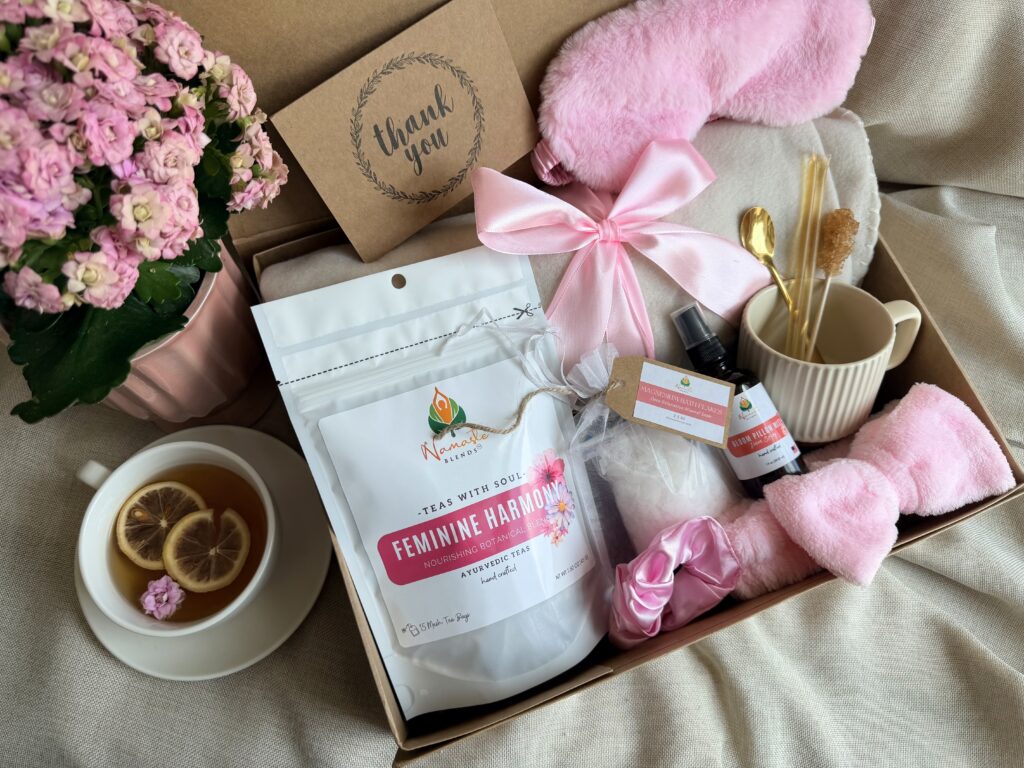 The Bloom Ritual Gift Box is a luxurious self-care gift designed to inspire peaceful moments of relaxation and everyday wellness. Featuring our handcrafted Feminine Harmony Herbal Tea, a cozy throw blanket, plush eye mask, satin scrunchie, magnesium bath flakes, Bloom pillow mist, ceramic tea mug, gold spoon, honey stick, and sugar stick, this beautifully curated collection transforms an ordinary tea break into a comforting self-care ritual. This premium gift set includes 15 food-grade mesh tea bags filled with our naturally caffeine-free botanical blend, handcrafted in small batches by Namaste Blends. Beautifully packaged and ready to gift, it's the perfect choice for birthdays, Mother's Day, Valentine's Day, bridal showers, holidays, or anyone who enjoys cozy tea moments, botanical wellness, and intentional self-care.