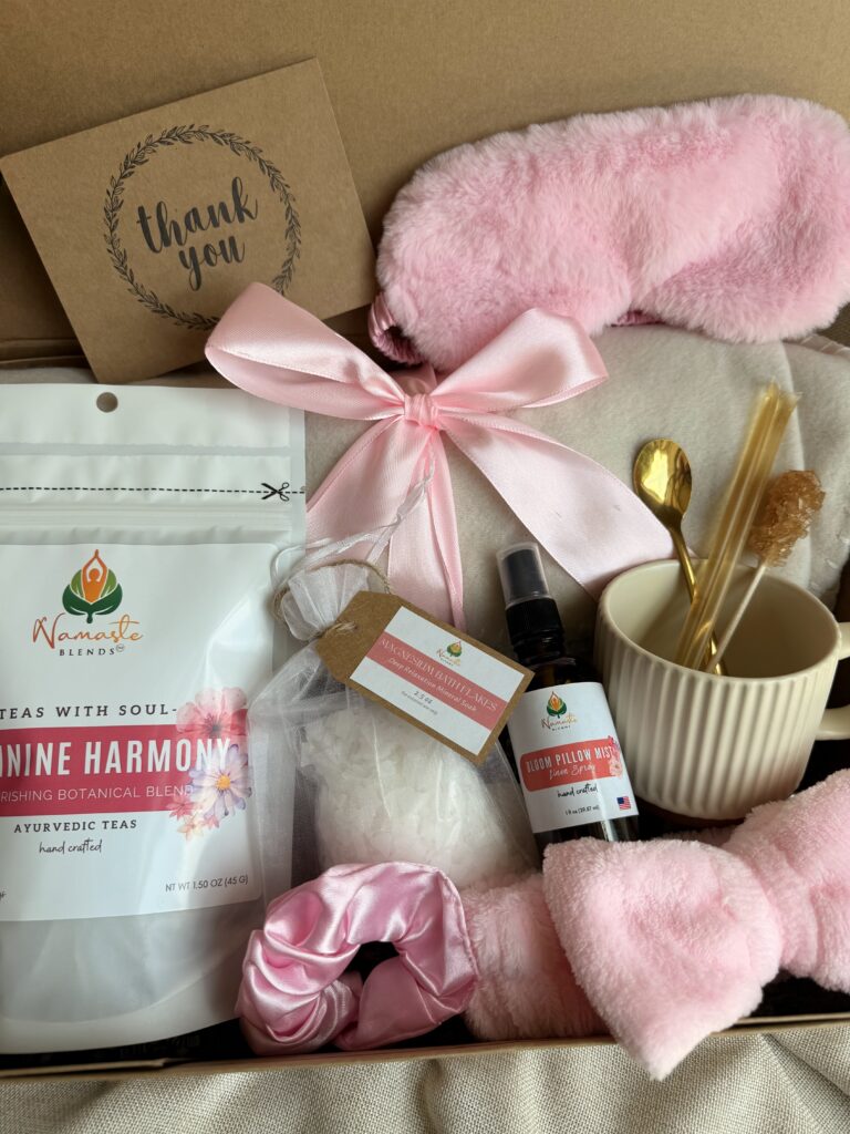 The Bloom Ritual Gift Box is a luxurious self-care gift designed to inspire peaceful moments of relaxation and everyday wellness. Featuring our handcrafted Feminine Harmony Herbal Tea, a cozy throw blanket, plush eye mask, satin scrunchie, magnesium bath flakes, Bloom pillow mist, ceramic tea mug, gold spoon, honey stick, and sugar stick, this beautifully curated collection transforms an ordinary tea break into a comforting self-care ritual. This premium gift set includes 15 food-grade mesh tea bags filled with our naturally caffeine-free botanical blend, handcrafted in small batches by Namaste Blends. Beautifully packaged and ready to gift, it's the perfect choice for birthdays, Mother's Day, Valentine's Day, bridal showers, holidays, or anyone who enjoys cozy tea moments, botanical wellness, and intentional self-care.