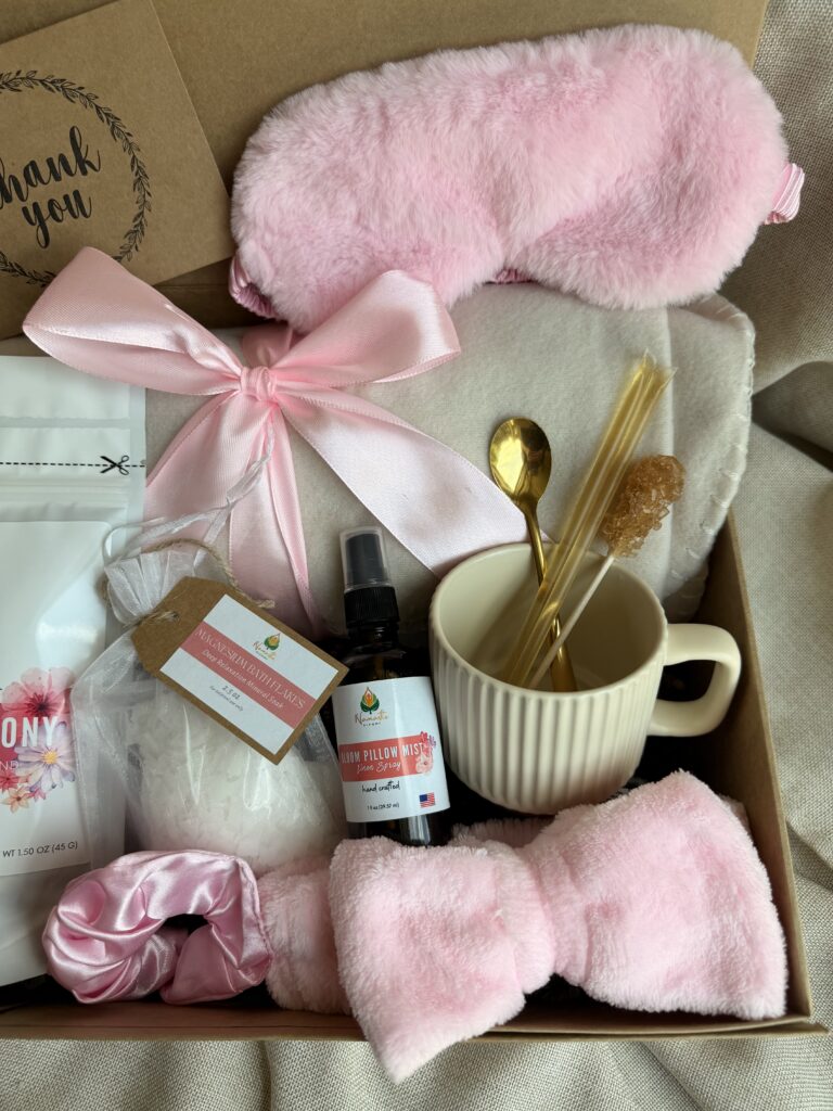 The Bloom Ritual Gift Box is a luxurious self-care gift designed to inspire peaceful moments of relaxation and everyday wellness. Featuring our handcrafted Feminine Harmony Herbal Tea, a cozy throw blanket, plush eye mask, satin scrunchie, magnesium bath flakes, Bloom pillow mist, ceramic tea mug, gold spoon, honey stick, and sugar stick, this beautifully curated collection transforms an ordinary tea break into a comforting self-care ritual. This premium gift set includes 15 food-grade mesh tea bags filled with our naturally caffeine-free botanical blend, handcrafted in small batches by Namaste Blends. Beautifully packaged and ready to gift, it's the perfect choice for birthdays, Mother's Day, Valentine's Day, bridal showers, holidays, or anyone who enjoys cozy tea moments, botanical wellness, and intentional self-care.