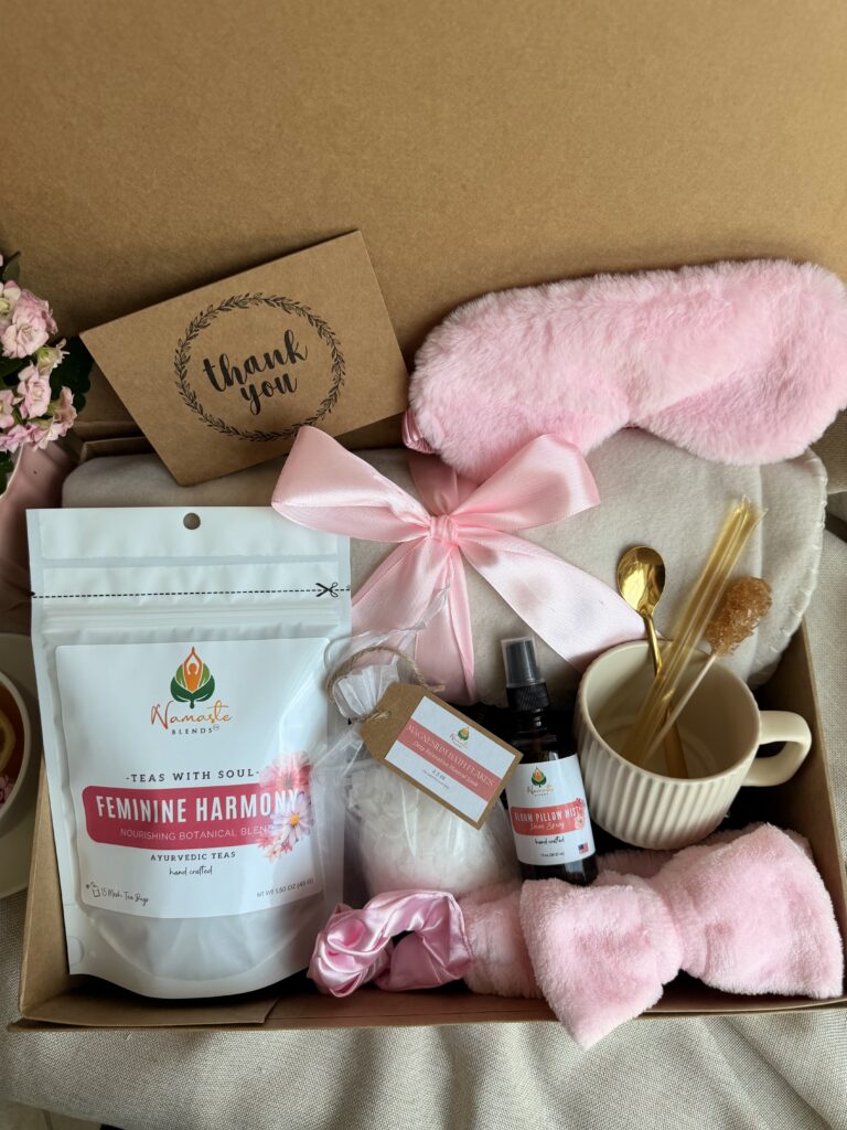 The Bloom Ritual Gift Box is a luxurious self-care gift designed to inspire peaceful moments of relaxation and everyday wellness. Featuring our handcrafted Feminine Harmony Herbal Tea, a cozy throw blanket, plush eye mask, satin scrunchie, magnesium bath flakes, Bloom pillow mist, ceramic tea mug, gold spoon, honey stick, and sugar stick, this beautifully curated collection transforms an ordinary tea break into a comforting self-care ritual. This premium gift set includes 15 food-grade mesh tea bags filled with our naturally caffeine-free botanical blend, handcrafted in small batches by Namaste Blends. Beautifully packaged and ready to gift, it's the perfect choice for birthdays, Mother's Day, Valentine's Day, bridal showers, holidays, or anyone who enjoys cozy tea moments, botanical wellness, and intentional self-care.