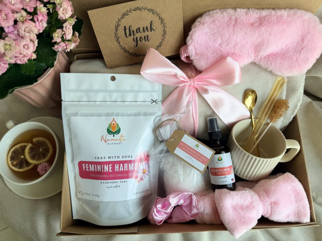 The Bloom Ritual Gift Box is a luxurious self-care gift designed to inspire peaceful moments of relaxation and everyday wellness. Featuring our handcrafted Feminine Harmony Herbal Tea, a cozy throw blanket, plush eye mask, satin scrunchie, magnesium bath flakes, Bloom pillow mist, ceramic tea mug, gold spoon, honey stick, and sugar stick, this beautifully curated collection transforms an ordinary tea break into a comforting self-care ritual. This premium gift set includes 15 food-grade mesh tea bags filled with our naturally caffeine-free botanical blend, handcrafted in small batches by Namaste Blends. Beautifully packaged and ready to gift, it's the perfect choice for birthdays, Mother's Day, Valentine's Day, bridal showers, holidays, or anyone who enjoys cozy tea moments, botanical wellness, and intentional self-care.