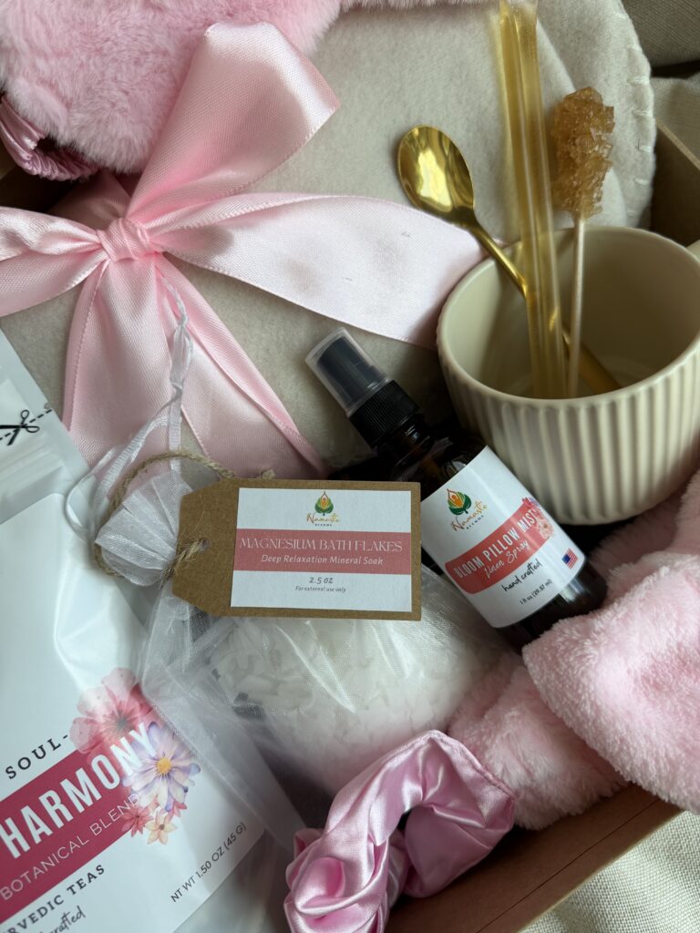 The Bloom Ritual Gift Box is a luxurious self-care gift designed to inspire peaceful moments of relaxation and everyday wellness. Featuring our handcrafted Feminine Harmony Herbal Tea, a cozy throw blanket, plush eye mask, satin scrunchie, magnesium bath flakes, Bloom pillow mist, ceramic tea mug, gold spoon, honey stick, and sugar stick, this beautifully curated collection transforms an ordinary tea break into a comforting self-care ritual. This premium gift set includes 15 food-grade mesh tea bags filled with our naturally caffeine-free botanical blend, handcrafted in small batches by Namaste Blends. Beautifully packaged and ready to gift, it's the perfect choice for birthdays, Mother's Day, Valentine's Day, bridal showers, holidays, or anyone who enjoys cozy tea moments, botanical wellness, and intentional self-care.