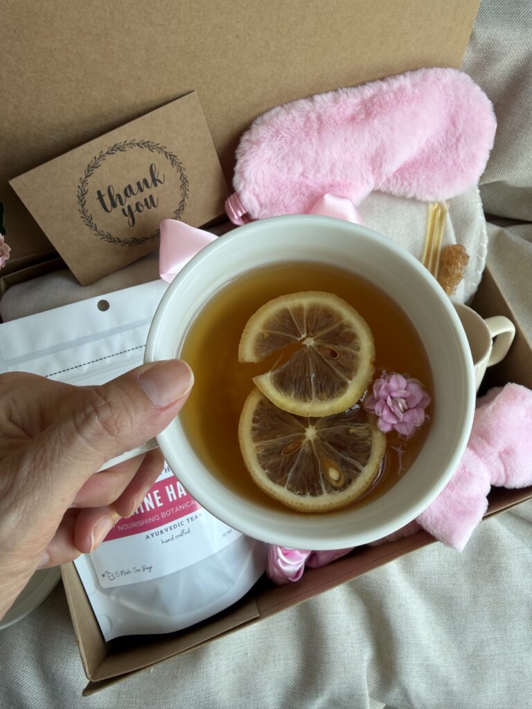The Bloom Ritual Gift Box is a luxurious self-care gift designed to inspire peaceful moments of relaxation and everyday wellness. Featuring our handcrafted Feminine Harmony Herbal Tea, a cozy throw blanket, plush eye mask, satin scrunchie, magnesium bath flakes, Bloom pillow mist, ceramic tea mug, gold spoon, honey stick, and sugar stick, this beautifully curated collection transforms an ordinary tea break into a comforting self-care ritual. This premium gift set includes 15 food-grade mesh tea bags filled with our naturally caffeine-free botanical blend, handcrafted in small batches by Namaste Blends. Beautifully packaged and ready to gift, it's the perfect choice for birthdays, Mother's Day, Valentine's Day, bridal showers, holidays, or anyone who enjoys cozy tea moments, botanical wellness, and intentional self-care.