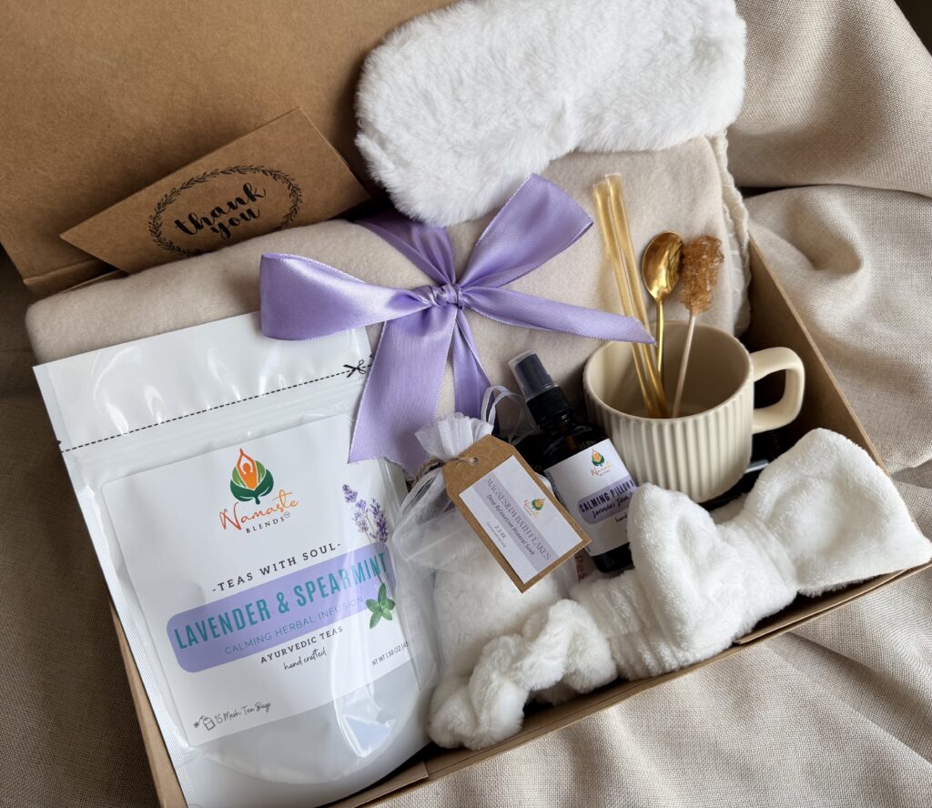 Serenity Ritual Gift Box featuring Lavender & Spearmint Herbal Tea, cozy blanket, plush eye mask, spa headband, magnesium bath flakes, calming pillow mist, ceramic tea mug, and self-care essentials by Namaste Blends.