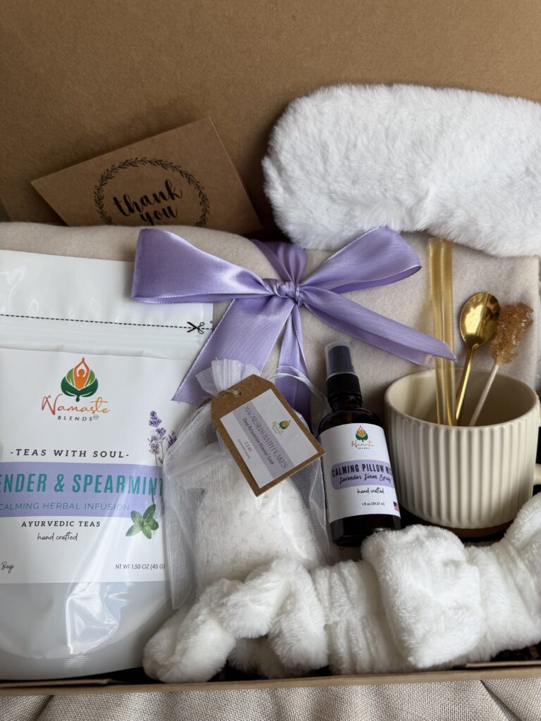 Serenity Ritual Gift Box featuring Lavender & Spearmint Herbal Tea, cozy blanket, plush eye mask, spa headband, magnesium bath flakes, calming pillow mist, ceramic tea mug, and self-care essentials by Namaste Blends.