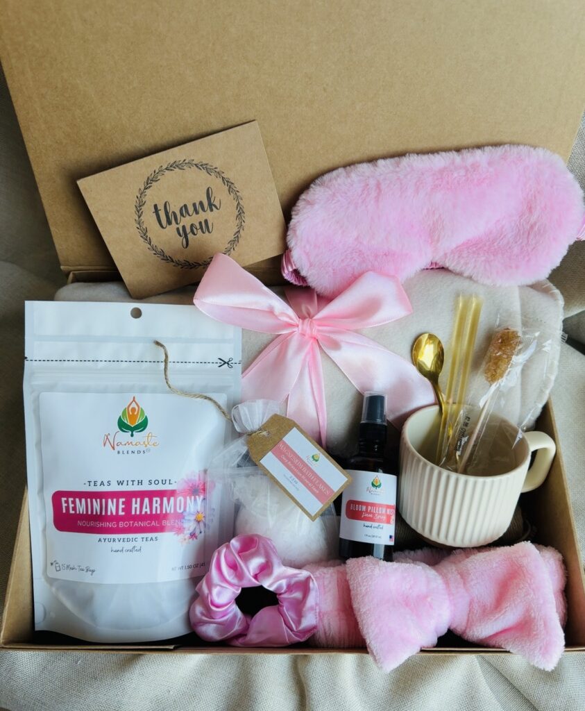 The Bloom Ritual Gift Box is a luxurious self-care gift designed to inspire peaceful moments of relaxation and everyday wellness. Featuring our handcrafted Feminine Harmony Herbal Tea, a cozy throw blanket, plush eye mask, satin scrunchie, magnesium bath flakes, Bloom pillow mist, ceramic tea mug, gold spoon, honey stick, and sugar stick, this beautifully curated collection transforms an ordinary tea break into a comforting self-care ritual. This premium gift set includes 15 food-grade mesh tea bags filled with our naturally caffeine-free botanical blend, handcrafted in small batches by Namaste Blends. Beautifully packaged and ready to gift, it's the perfect choice for birthdays, Mother's Day, Valentine's Day, bridal showers, holidays, or anyone who enjoys cozy tea moments, botanical wellness, and intentional self-care.